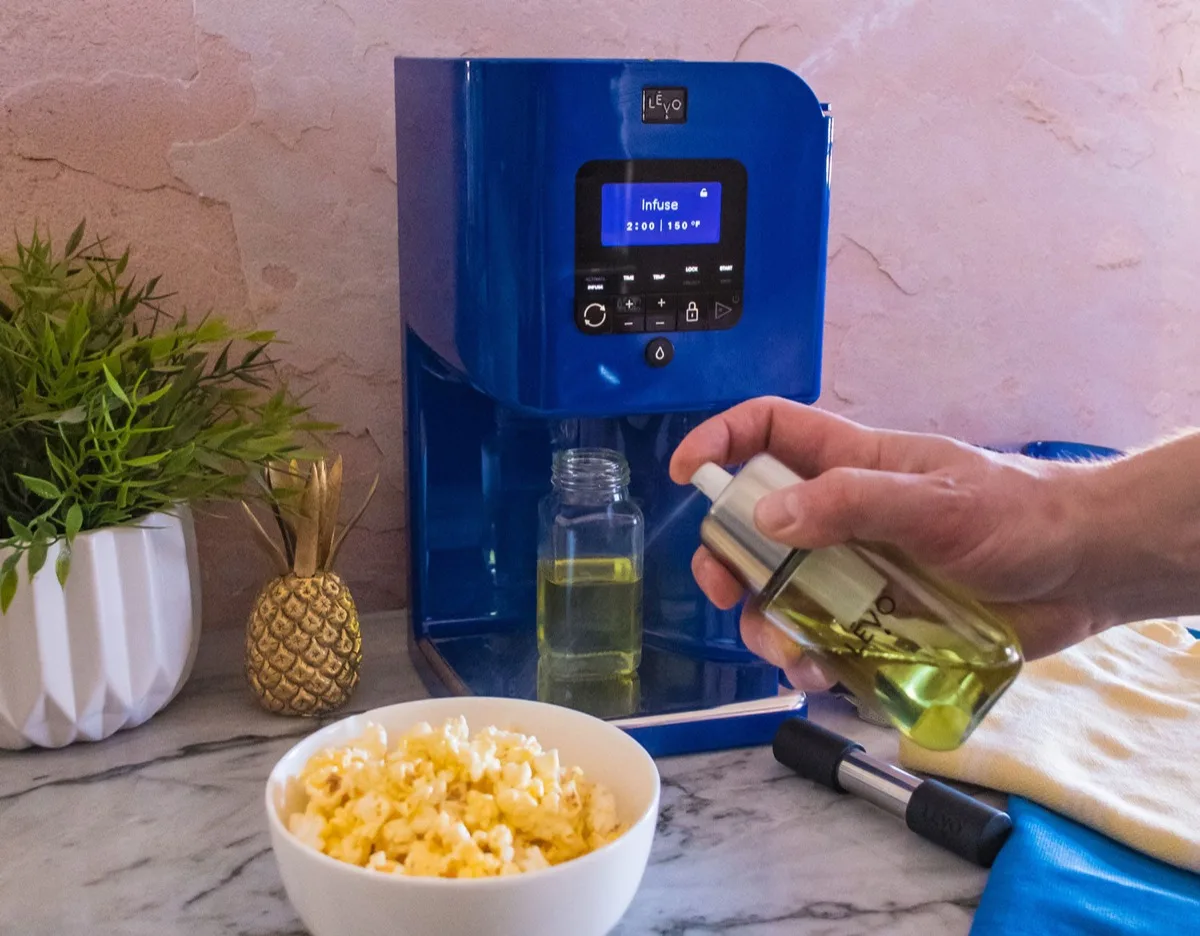 LĒVO II oil infuser on a kitchen counter with infused oil and popcorn